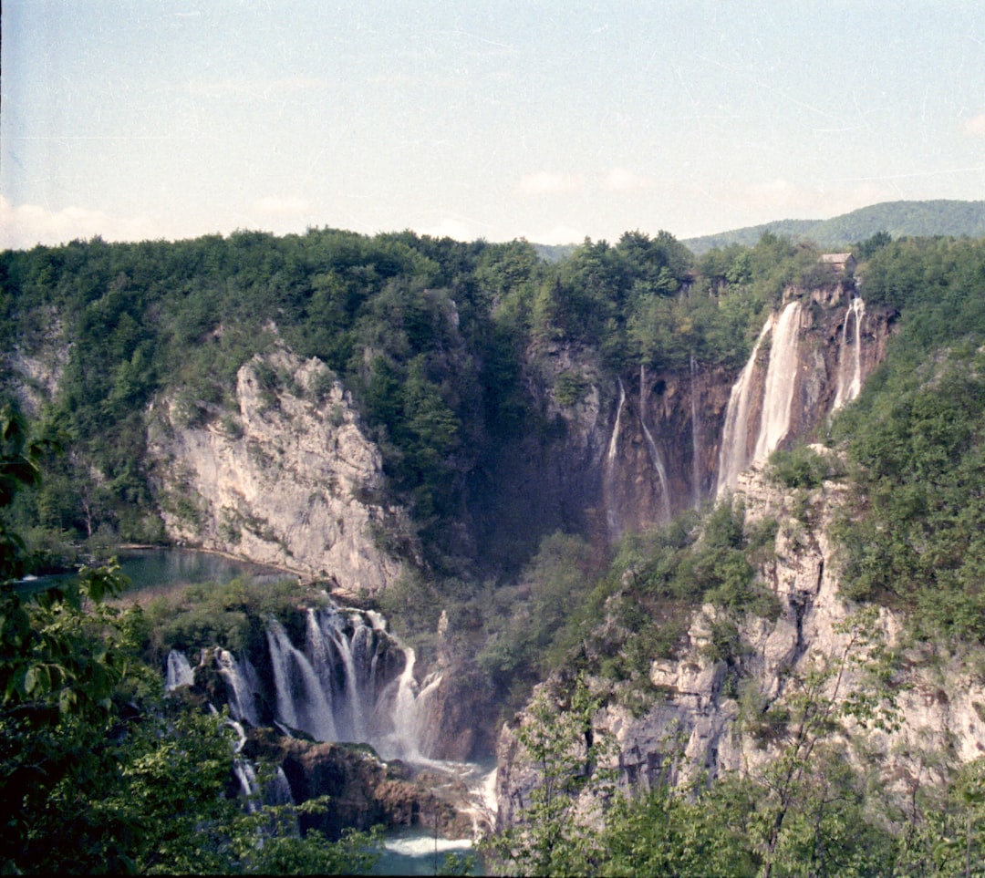 Cascading terraced waterfalls through green forest at Plitvice