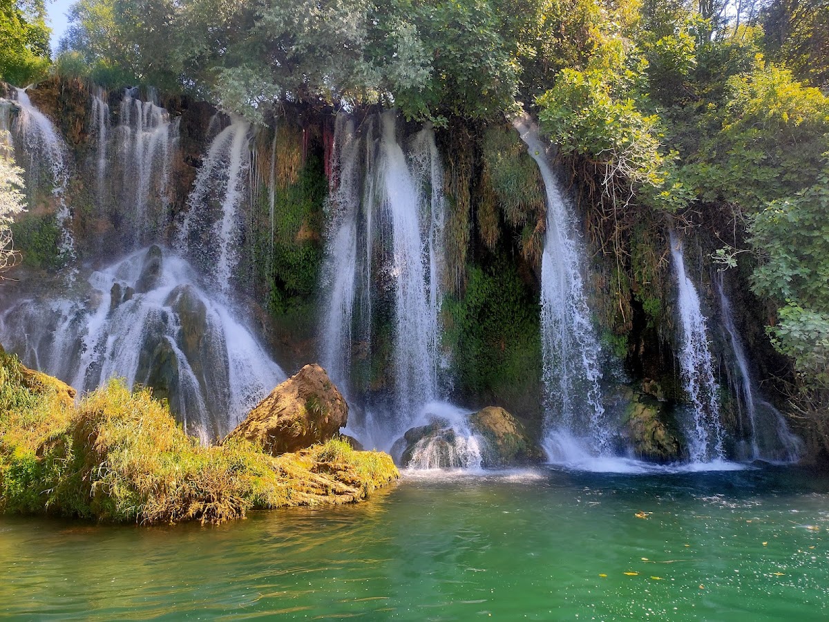 Swimming in natural waterfall pool surrounded by nature